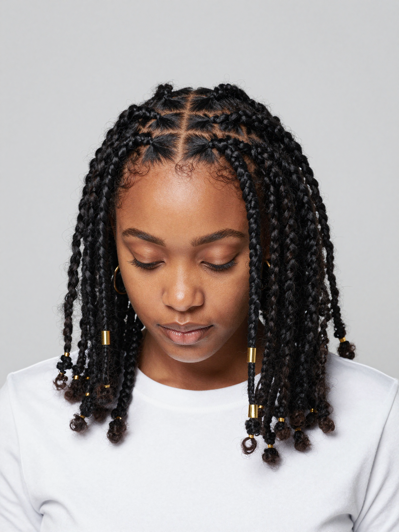 Fulani braids with cornrowed center part and hanging box braids on coily natural hair