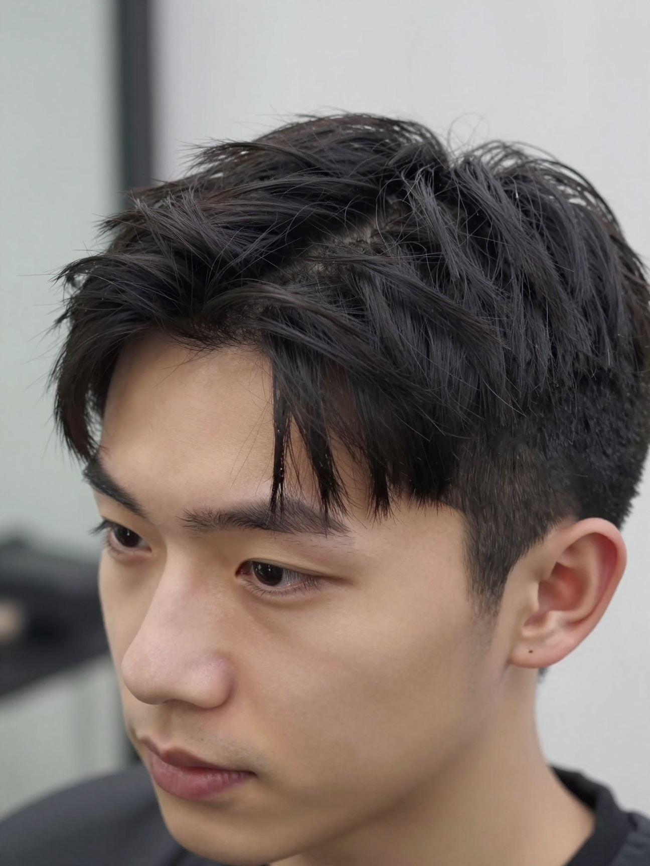 Close-up of matte clay worked through mid-length hair for a middle part style